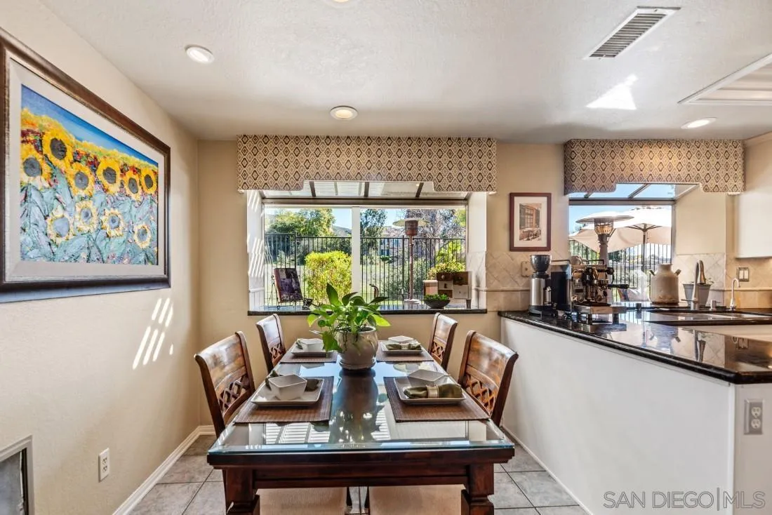 13755 Royal Melbourne Square San Diego, CA 92128 - Photo 19 of 75 a dining room with furniture a large window and wooden floor