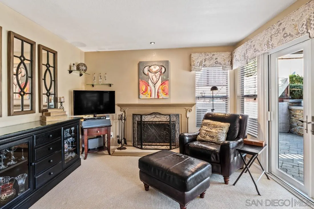 13755 Royal Melbourne Square San Diego, CA 92128 - Photo 20 of 75 a living room with furniture a flat screen tv and a fireplace