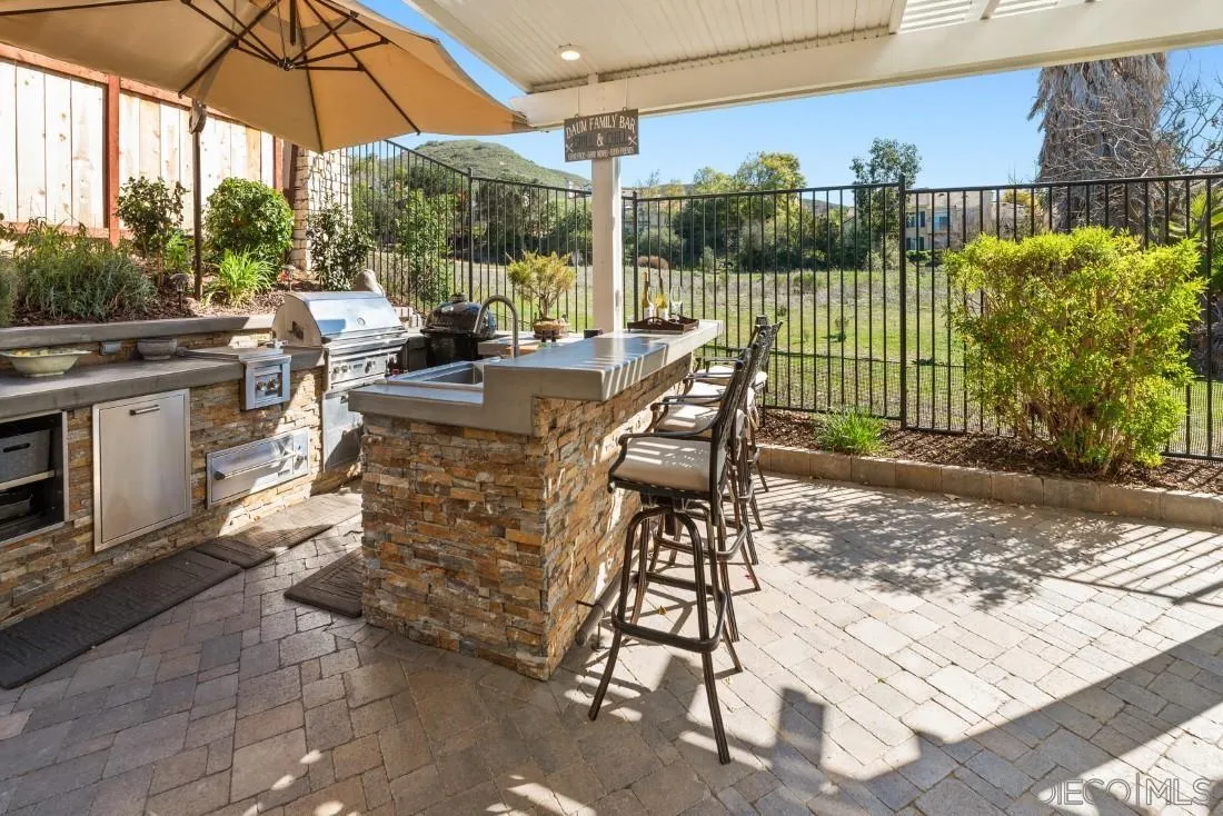 13755 Royal Melbourne Square San Diego, CA 92128 - Photo 27 of 75 a view of a patio with a table chairs and a floor to ceiling window