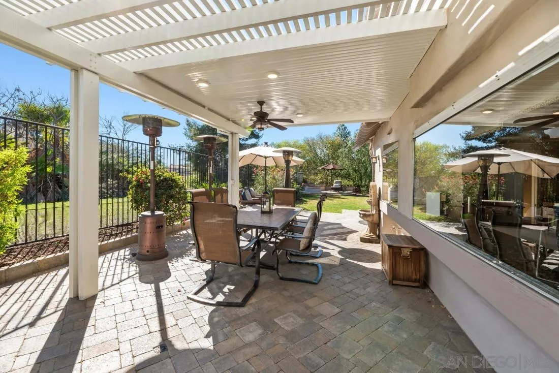 13755 Royal Melbourne Square San Diego, CA 92128 - Photo 35 of 75 a view of a patio with table and chairs potted plants with floor to ceiling window