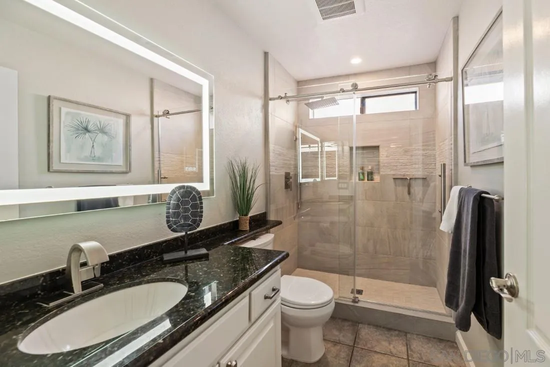 13755 Royal Melbourne Square San Diego, CA 92128 - Photo 49 of 75 a bathroom with a granite countertop sink toilet and shower