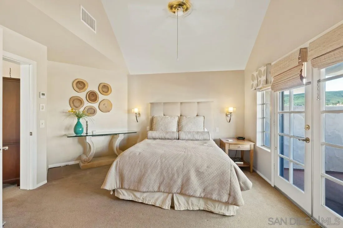 13755 Royal Melbourne Square San Diego, CA 92128 - Photo 51 of 75 a spacious bedroom with a bed and a chandelier