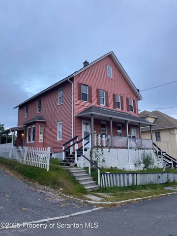 a front view of a house with a garden and plants