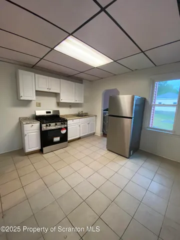 a kitchen with stainless steel appliances granite countertop a refrigerator and a stove top oven