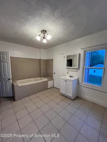 a bathroom with a tub sink and mirror