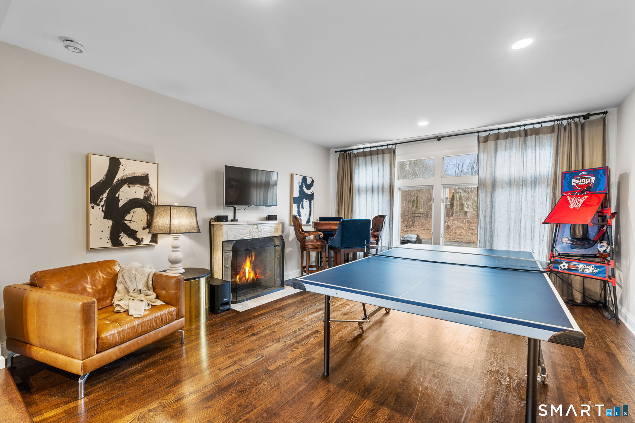 326 Thayer Pond Road Wilton, CT 06897 - Photo 9 of 40 a living room with furniture flat screen tv and a fireplace