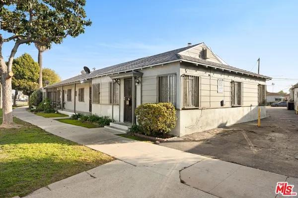 a front view of a house with a garden and parking