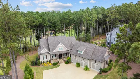 an aerial view of a house with swimming pool and a yard