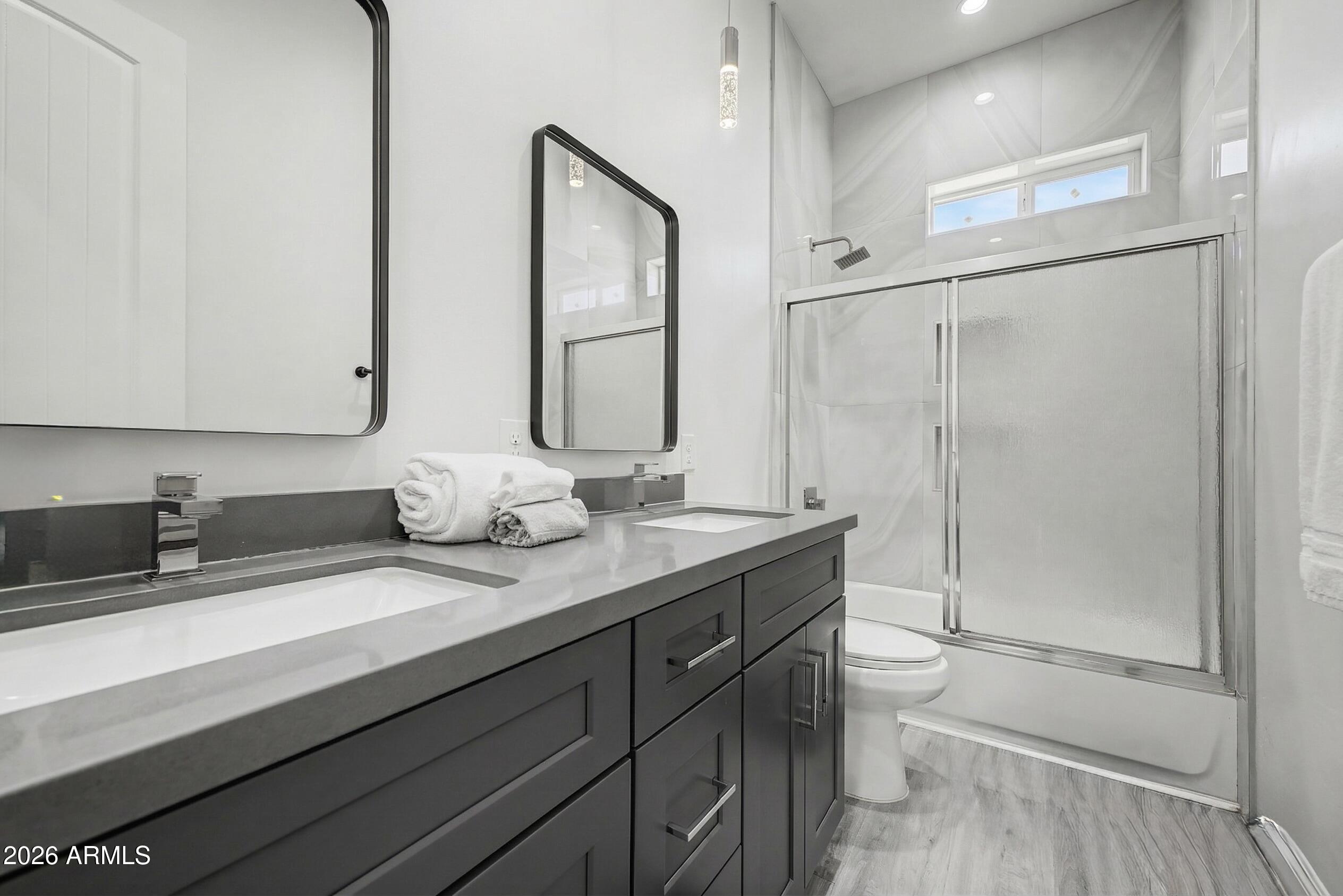 1344 East Polk Street, Unit B Phoenix, AZ 85006 - Photo 18 of 27 a bathroom with a granite countertop sink a toilet and a mirror