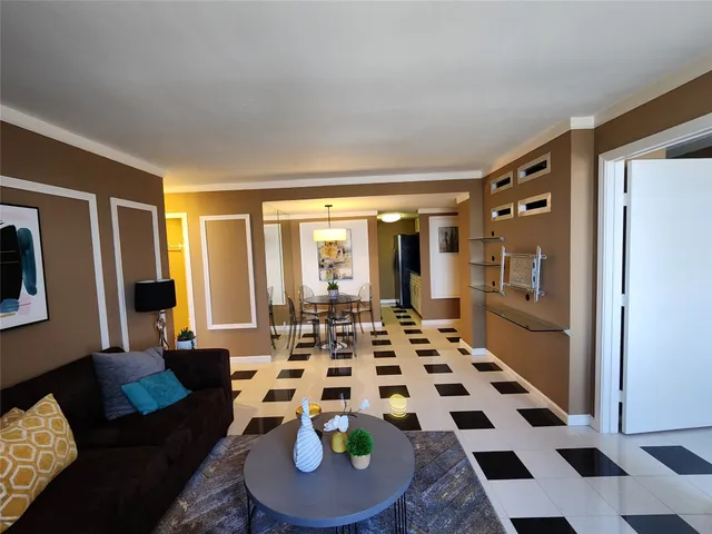 a living room with a black white checkered floor with couches and a coffee table