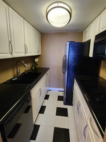 a kitchen with a sink a refrigerator and cabinets