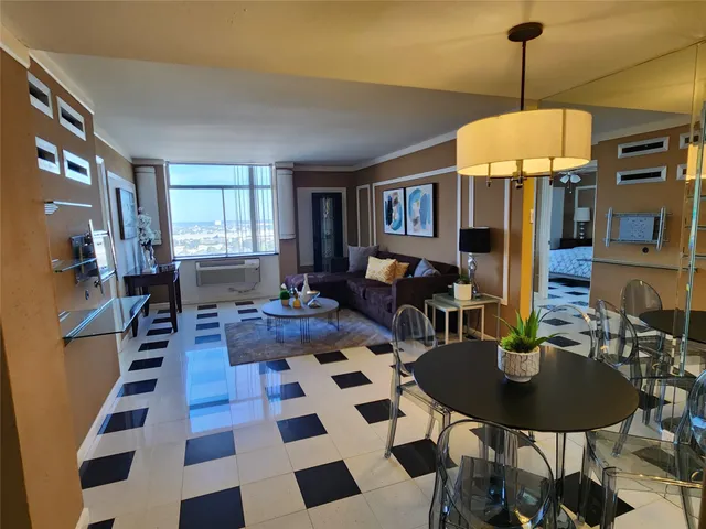 a room with a black white checkered floor with couches and a coffee table