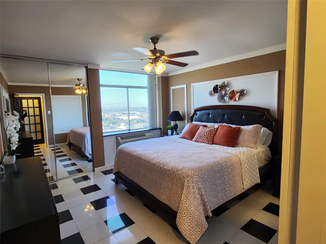 a bedroom with a large bed and a chandelier
