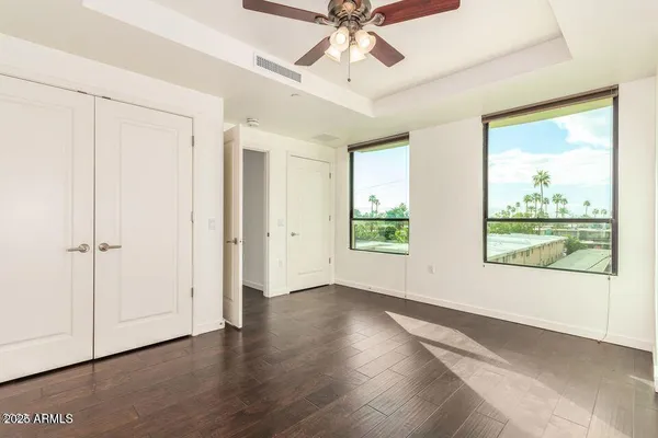 a view of an empty room with a window and wooden floor