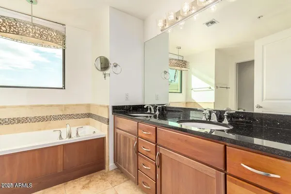 a bathroom with a tub sink and mirror