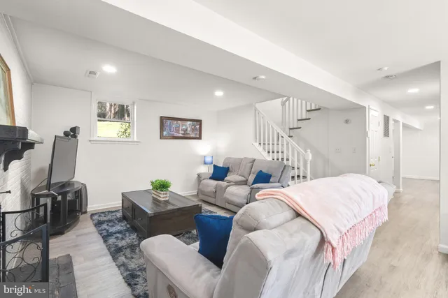 a living room with furniture a desk and chair with wooden floor