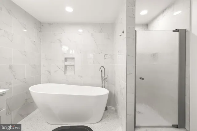 a bathroom with a white bath tub a toilet and a shower