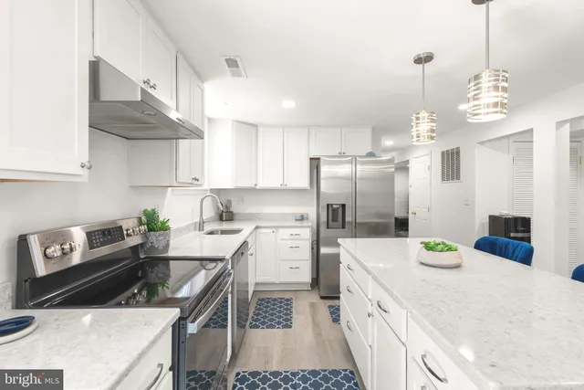 a kitchen with stainless steel appliances granite countertop a sink stove and refrigerator