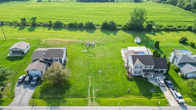 an aerial view of a house with a garden and lake view