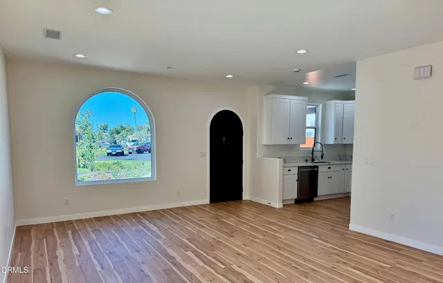 a view of a kitchen with a fridge wooden floor and windows