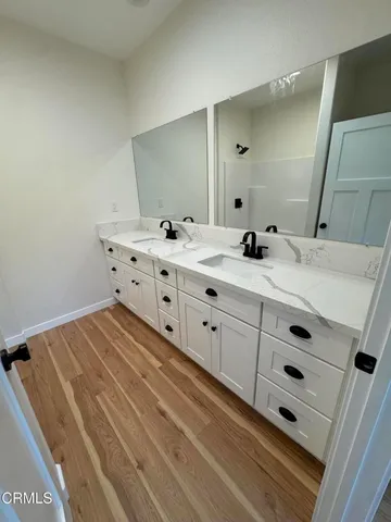 a view of an empty room with wooden floor and windows