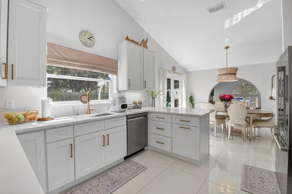 a kitchen with white cabinets and white appliances