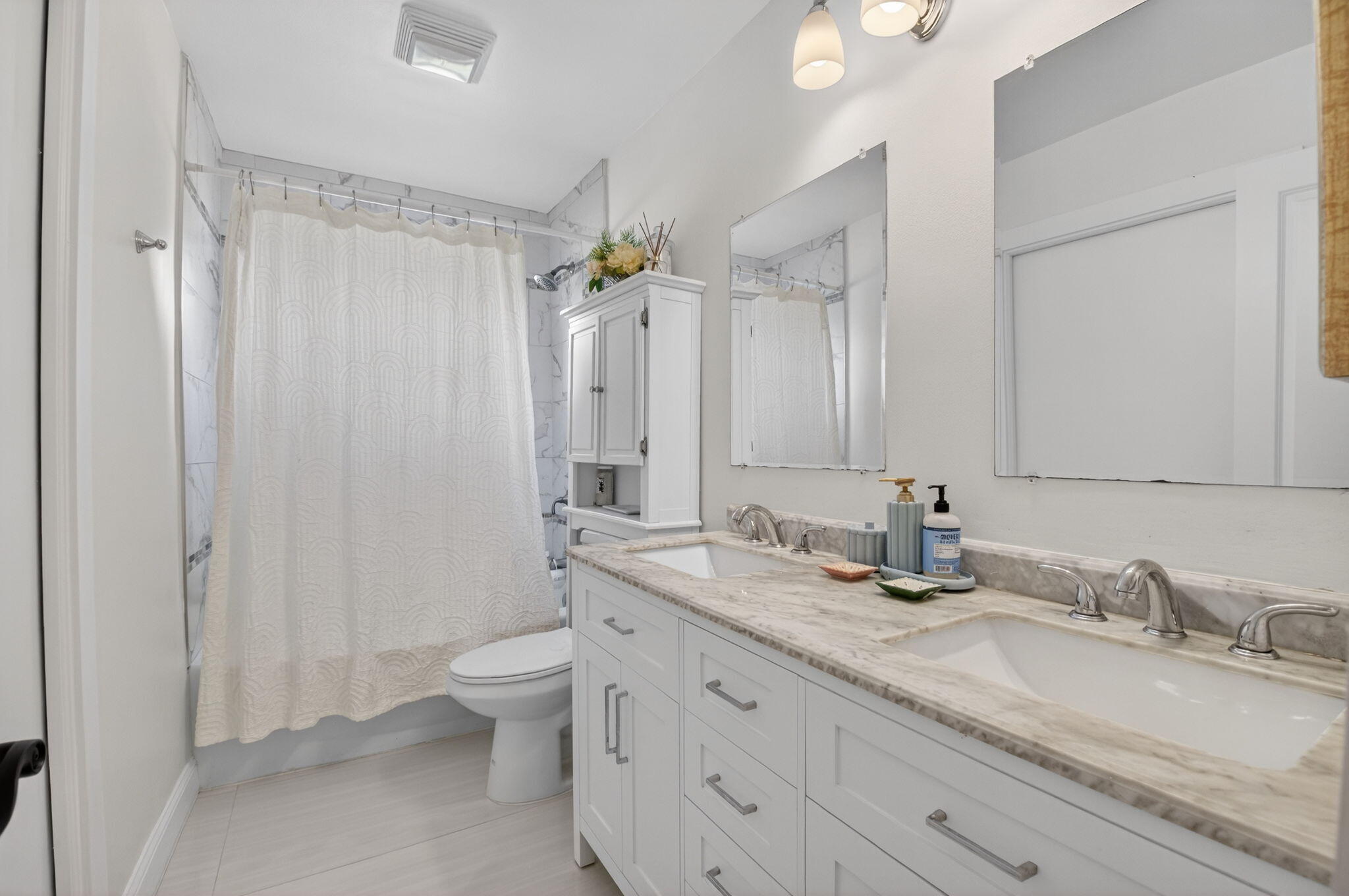 2402 Northwest 30th Street Boca Raton, FL 33431 - Photo 24 of 45 a bathroom with double vanity sinks a toilet and a large mirror