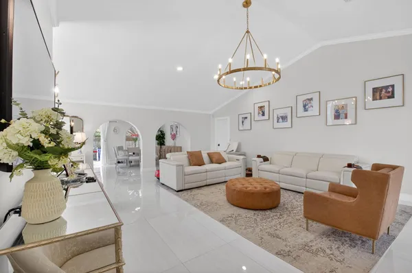 a living room with furniture potted plant and a chandelier