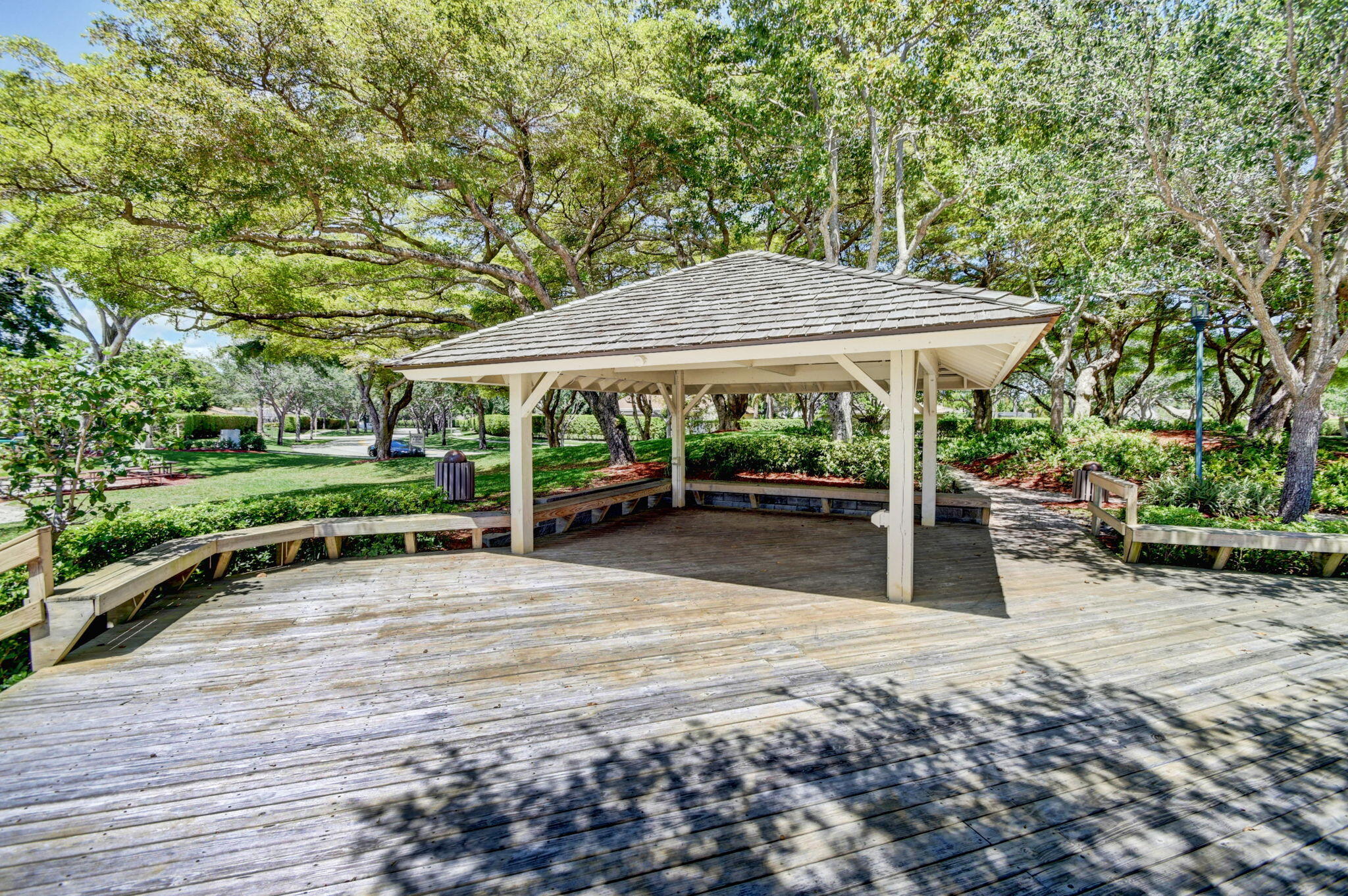 2402 Northwest 30th Street Boca Raton, FL 33431 - Photo 42 of 45 a view of a patio with table and chairs under an umbrella with large trees