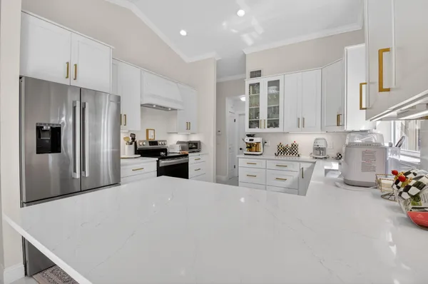 a kitchen with granite countertop a sink a stove and cabinets
