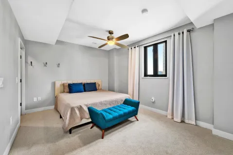 a bedroom with a bed and a ceiling fan