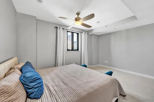 a bedroom with a bed and a ceiling fan