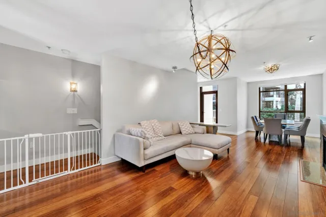 a living room with furniture a wooden floor and a chandelier