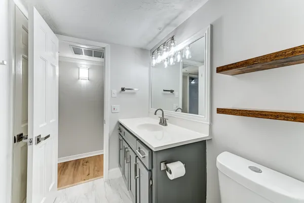 a bathroom with a sink toilet and mirror