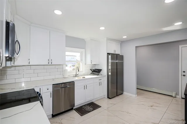 a kitchen with a sink a refrigerator and cabinets