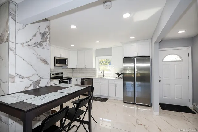 a kitchen with stainless steel appliances kitchen island granite countertop a refrigerator and a stove top oven