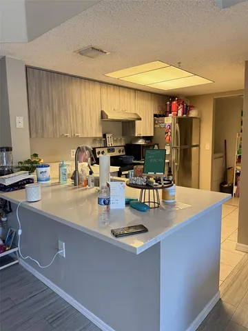 a kitchen with stainless steel appliances granite countertop a sink a stove and a refrigerator