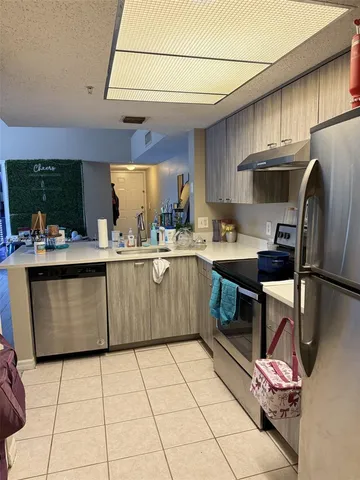 a kitchen with a sink a stove a refrigerator and cabinets