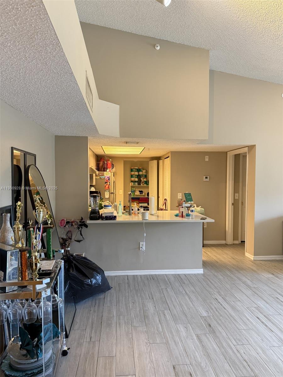 5015 Wiles Road, Unit 207 Coconut Creek, FL 33073 - Photo 5 of 11 a view of room with wooden floor