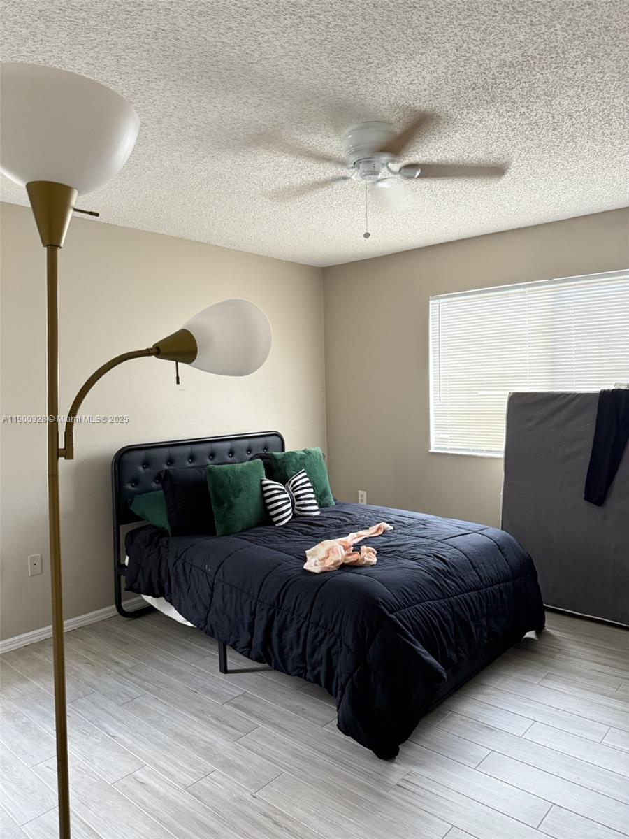 5015 Wiles Road, Unit 207 Coconut Creek, FL 33073 - Photo 8 of 11 a bedroom with a bed window and a mirror