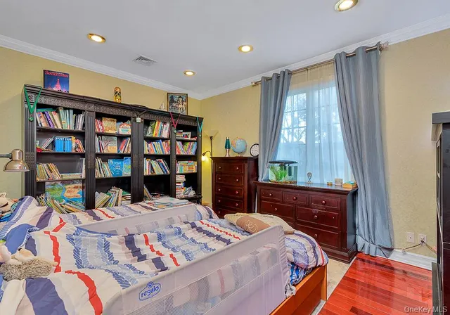 a bedroom with a bed a dresser and a book shelf