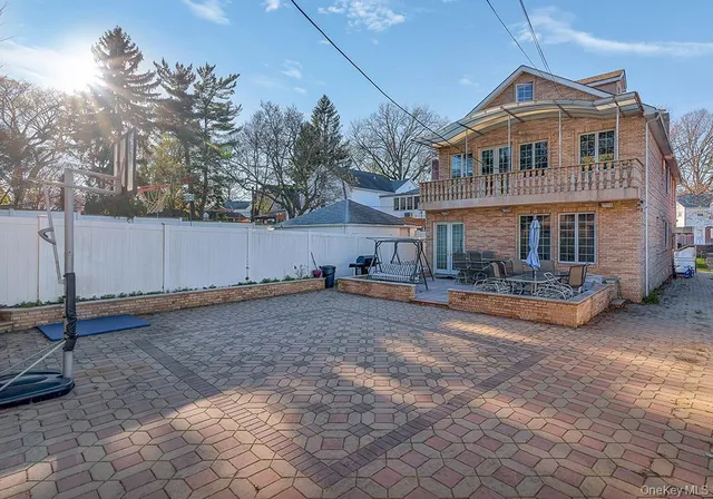 a view of a white house with a yard and large trees