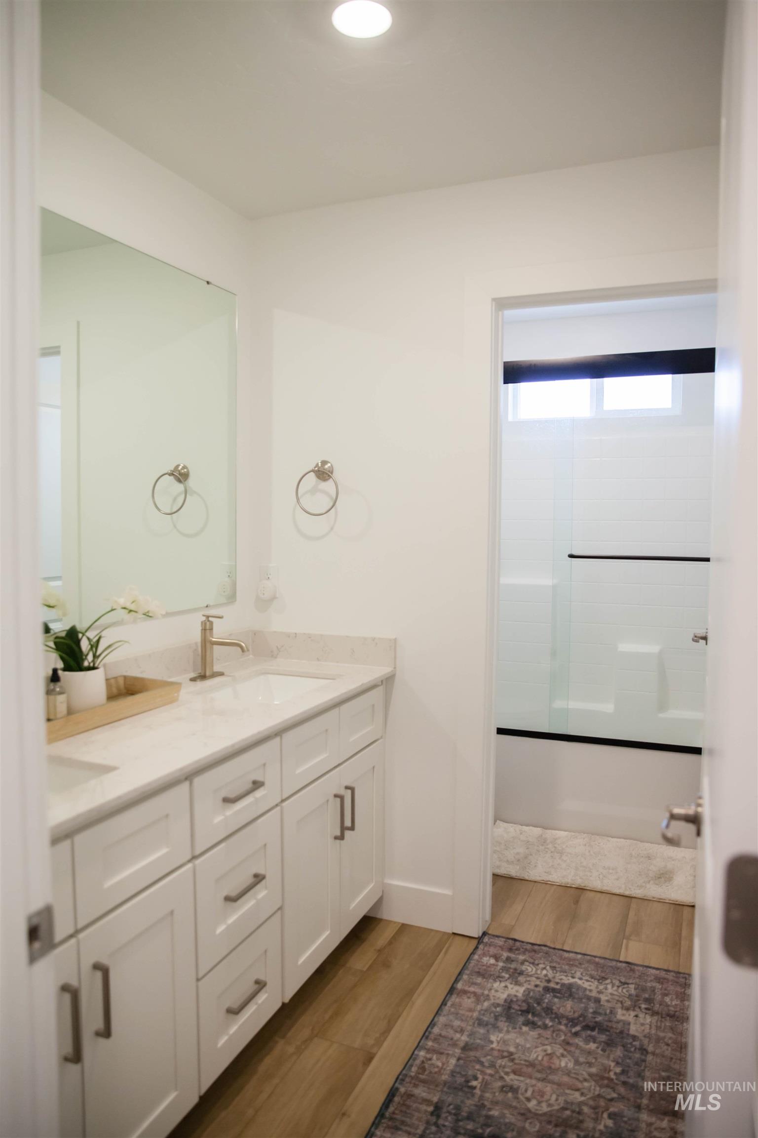 151 Insight Court Middleton, ID 83644 - Photo 26 of 35 Bathroom with double vanity, light wood finished floors, and shower / bath combination with glass door