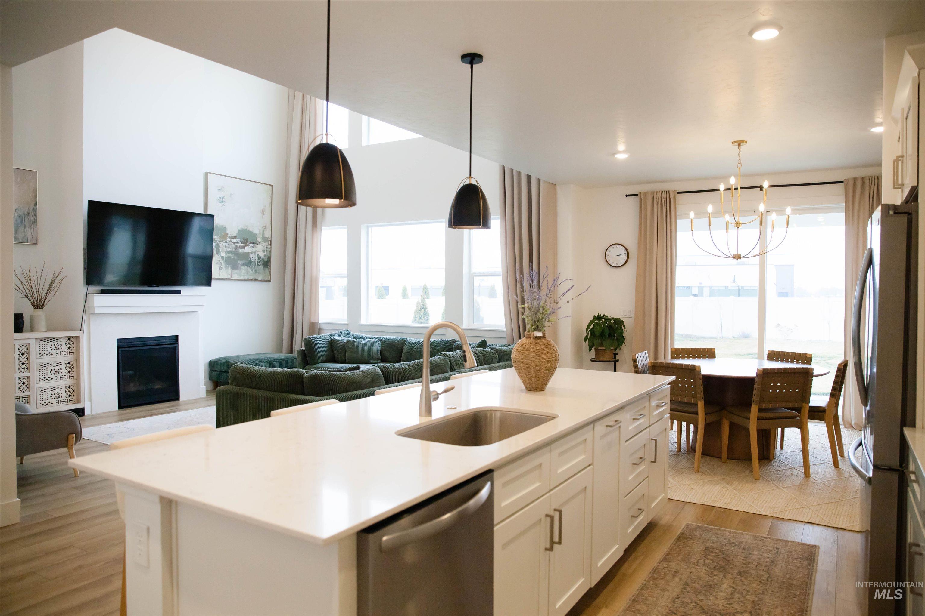 151 Insight Court Middleton, ID 83644 - Photo 35 of 35 Kitchen with an island with sink, white cabinets, stainless steel appliances, open floor plan, and hanging lights
