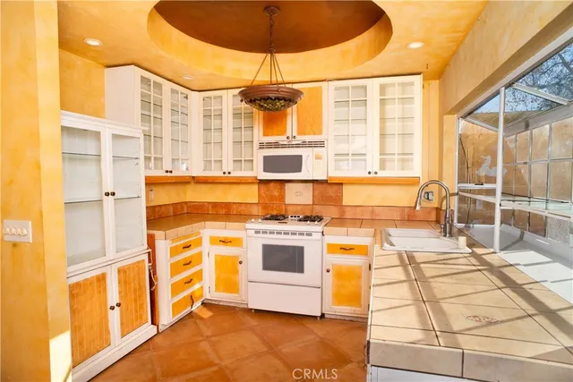 a kitchen with stainless steel appliances kitchen island granite countertop a stove and a white cabinets