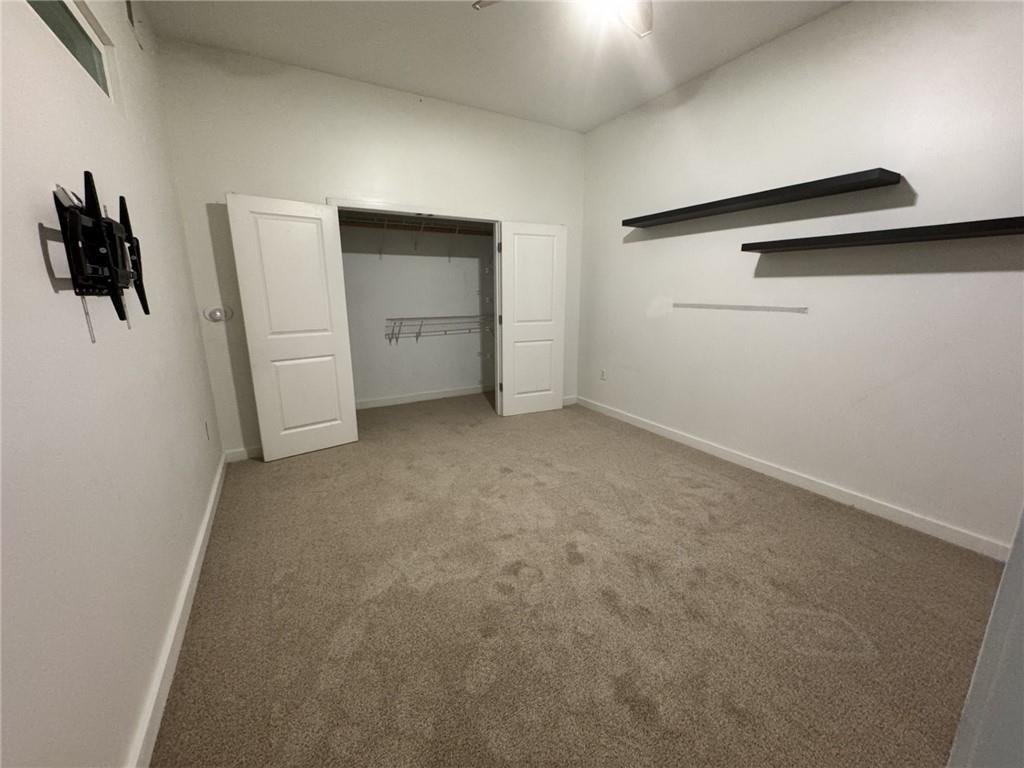 250 Pharr Road Northeast, Unit 601 Atlanta, GA 30305 - Photo 13 of 34 an empty room with closet and windows
