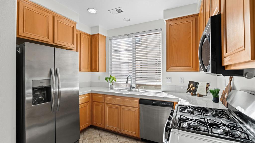 1280 Haglar Way, Unit 2 Chula Vista, CA 91913 - Photo 10 of 35 a kitchen with stainless steel appliances granite countertop a sink stove refrigerator and cabinets