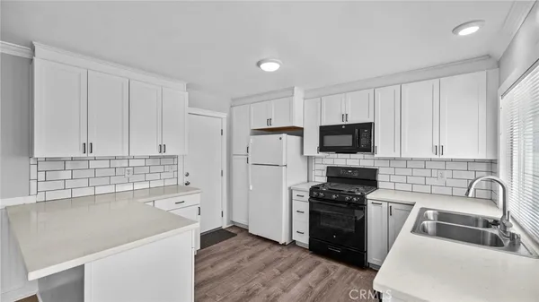 a kitchen with white cabinets and white appliances