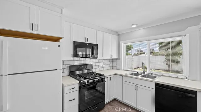 a kitchen with a sink and a stove next to a window