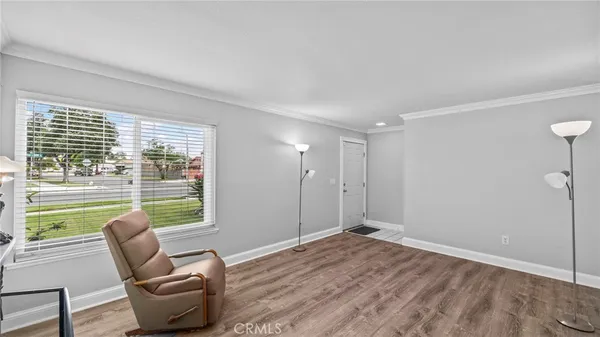 a view of workspace and bedroom with furniture and wooden floor